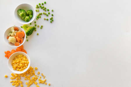 Frozen vegetables in bowls on white backgroundの写真素材