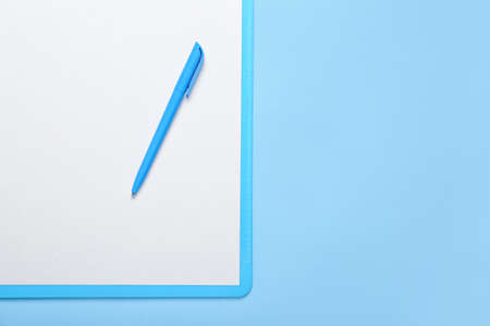 Clipboard with blank paper sheet and pen on color backgroundの写真素材