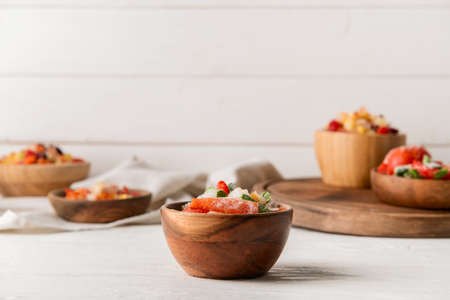 Frozen vegetables in bowl on light background