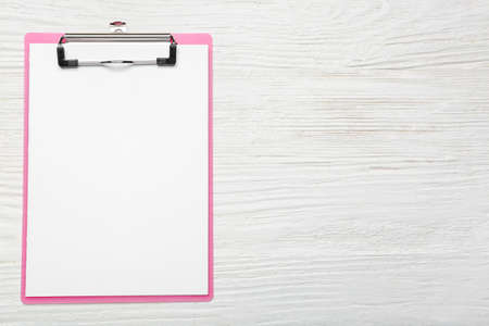 Clipboard with blank paper sheet on wooden backgroundの写真素材