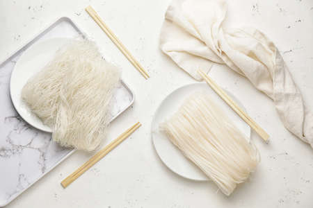 Raw rice noodles with chopsticks on white backgroundの写真素材