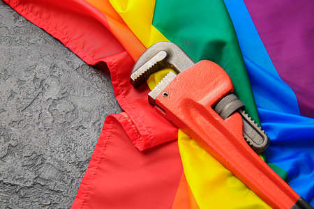 Adjustable wrench and rainbow LGBT flag on dark backgroundの写真素材