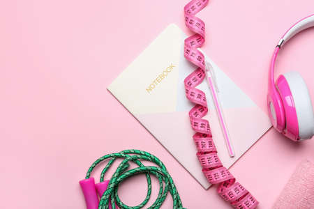 Measuring tape and notebook on color backgroundの写真素材