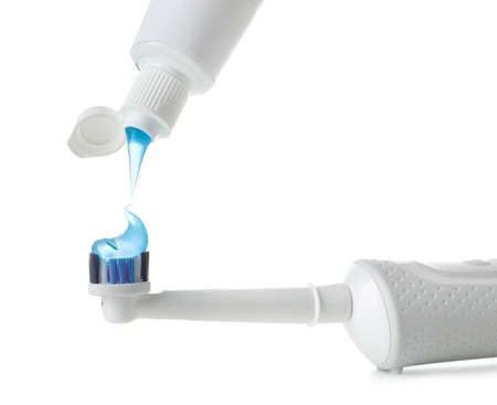 Squeezing of paste on tooth brush against white background