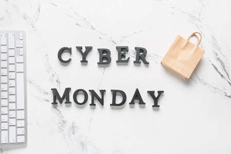 Computer keyboard with shopping bag and text CYBER MONDAY on white background