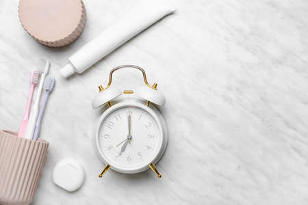 Alarm clock and set of oral care products on light backgroundの写真素材