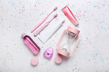 Hourglass and set of bath accessories on light background