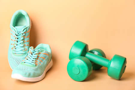 Sportive shoes and dumbbells on light backgroundの写真素材