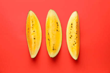 Cut yellow watermelon on color backgroundの写真素材