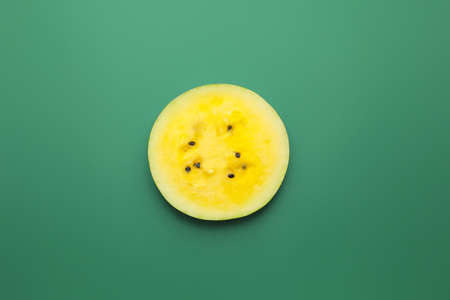Cut yellow watermelon on color backgroundの写真素材