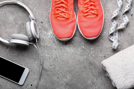 Sportive shoes, headphones and mobile phone on gray backgroundの写真素材