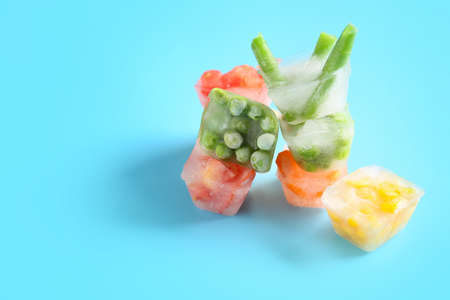 Different frozen vegetables on color backgroundの写真素材