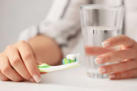 Woman with tooth brush and glass of water, closeupの写真素材