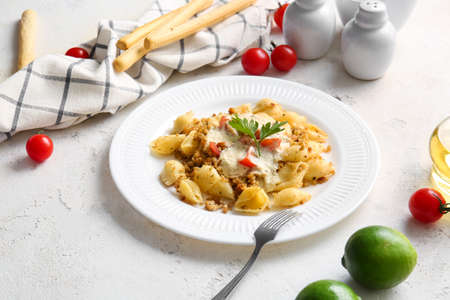 Plate with tasty conchiglie pasta on white backgroundの写真素材