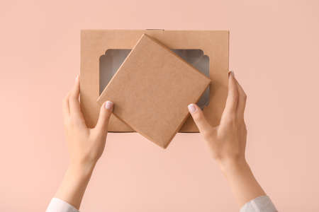 Hands with cardboard boxes on color backgroundの写真素材