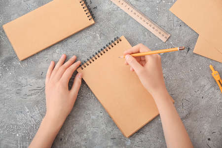 Woman with blank notebook on dark background
