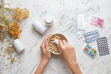 Woman making herbal based medicines on table