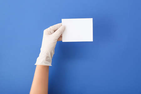 Female doctor with blank paper on color backgroundの写真素材
