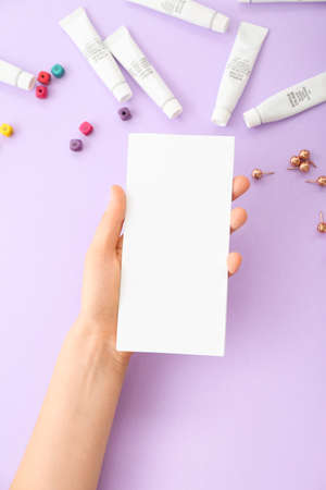 Female hand with blank paper on color backgroundの写真素材