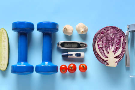 Vegetables, dumbbells, lancet pen and glucometer on color background. Diabetes conceptの写真素材