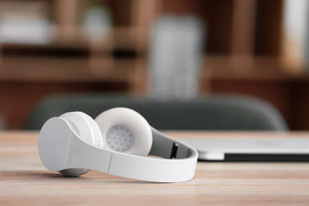 Modern headphones on table in office