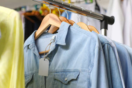 Clothes on hangers with blank paper labelsの写真素材