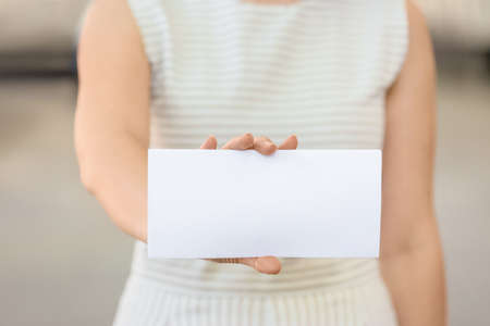 Woman with blank paper sheet outdoorsの写真素材