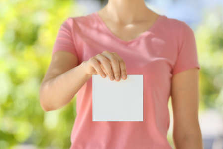 Woman with blank paper sheet outdoorsの写真素材