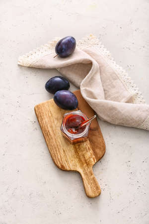 Glass jar with delicious homemade plum jam on table