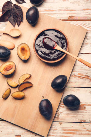 Bowl with delicious homemade plum jam on wooden backgroundの写真素材