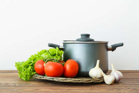 Cooking pot with vegetables on wooden tableの写真素材