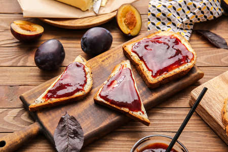 Slices of bread with delicious homemade plum jam on wooden backgroundの写真素材