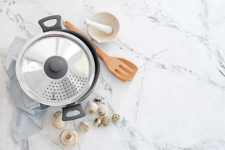 Composition with cooking pot, mushrooms and eggs on light background