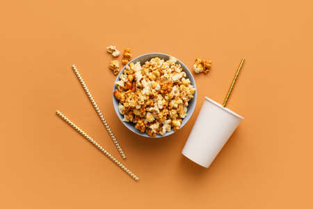 Tasty popcorn and cola on color backgroundの写真素材