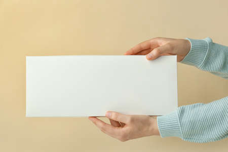Hands with blank cardboard box on color background