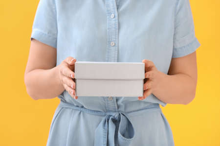 Woman with blank cardboard box on color backgroundの写真素材