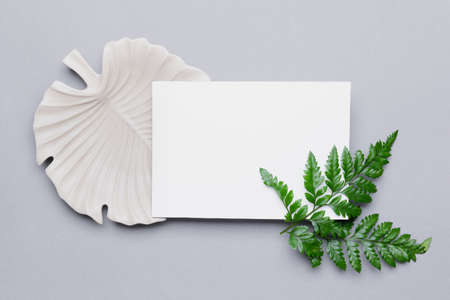 Composition with blank paper sheet on gray background