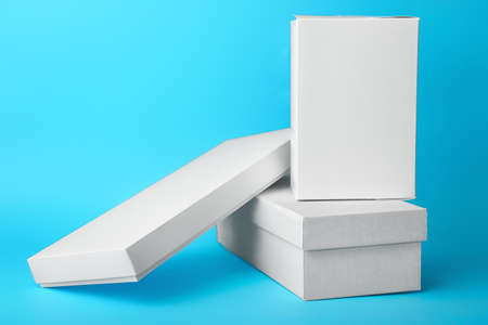 Blank cardboard boxes on color background