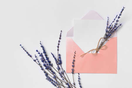 Envelope with blank paper sheet and flowers on white backgroundの写真素材
