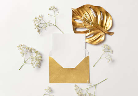 Envelope with blank paper sheet and flowers on white backgroundの写真素材