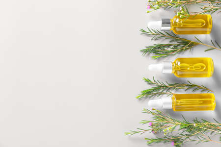 Bottles with essential oil on light background