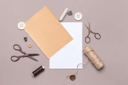 Composition with blank paper sheet and sewing supplies on color background