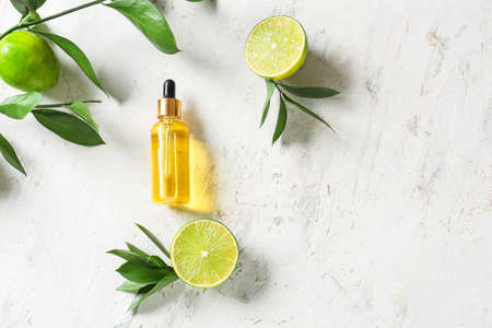 Bottle with citrus essential oil on light backgroundの写真素材
