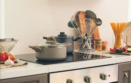 Cooking pots on electric stove in kitchenの写真素材