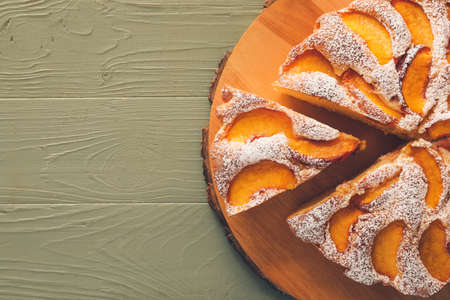 Board with tasty peach pie on wooden backgroundの写真素材