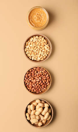 Bowls with tasty peanut butter and nuts on color backgroundの写真素材