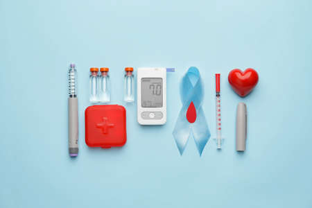 Glucometer with medications, syringes, awareness ribbon and heart on color background. Diabetes conceptの写真素材