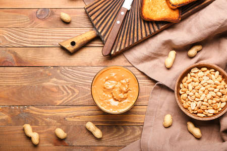 Bowl with tasty peanut butter on wooden backgroundの写真素材
