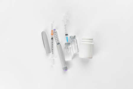 Syringes, bottles of insulin and pills on white background. Diabetes conceptの写真素材