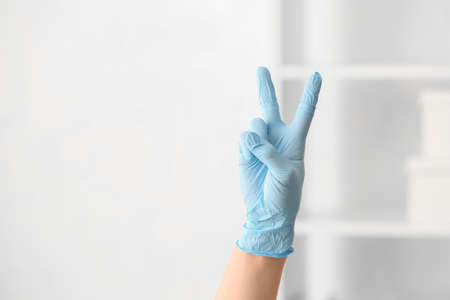Hand in protective glove showing victory gesture, closeup